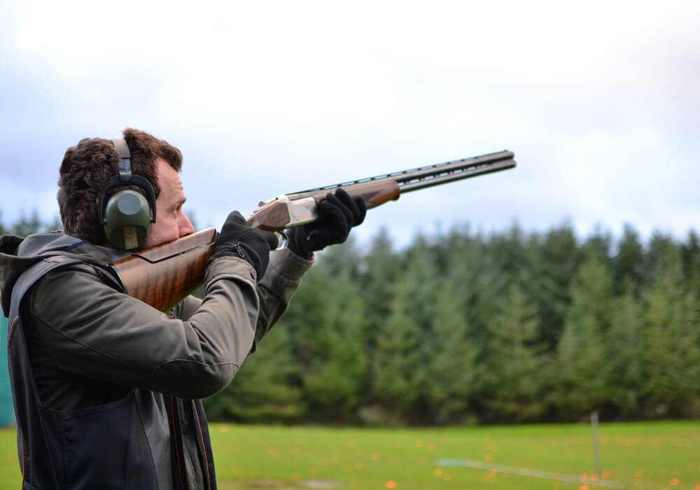 Man trying clay pigeon shooting on stag do 