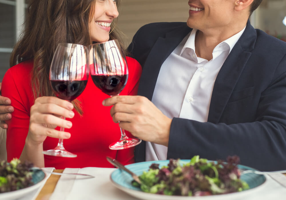Young couple celebrating Valentines Day with dinner and red wine