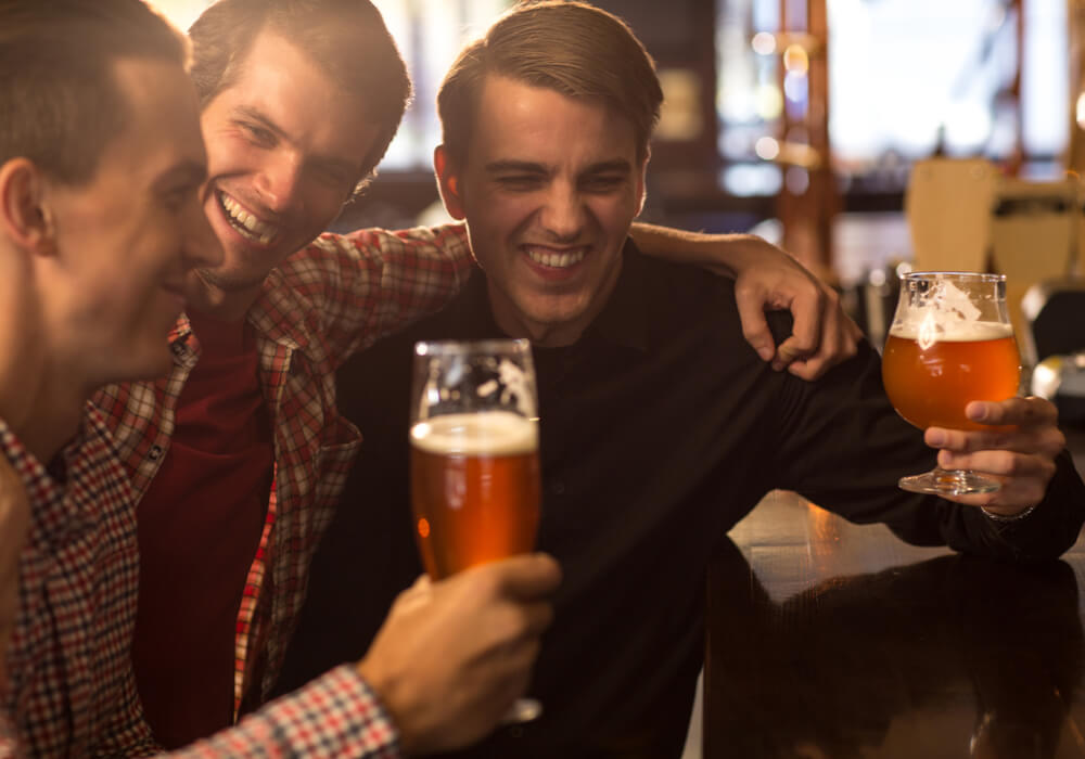 Men at a comedy club enjoying pints of beer 