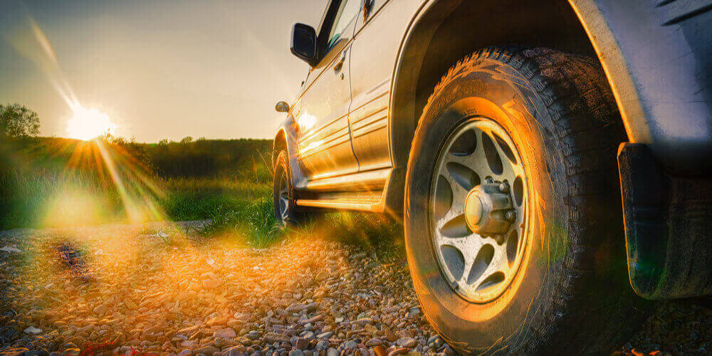 side of car and wheel with countryside background