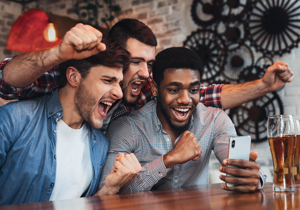 Men celebrating whilst playing treasure hunt pub challenge stag activity