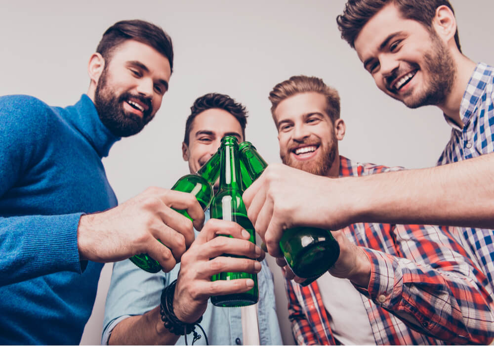 Men celebrating their stag do with bottles of beer