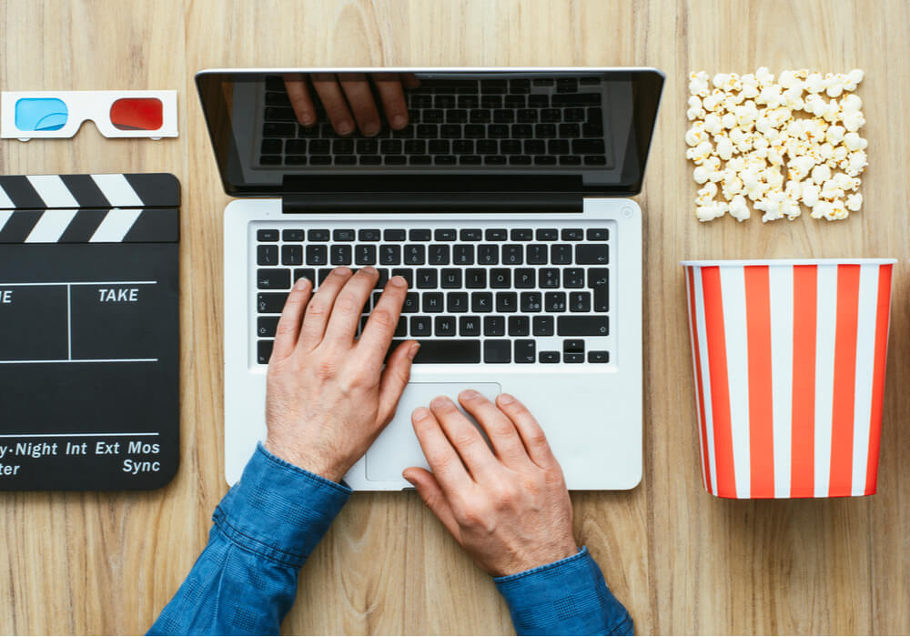 Someone getting ready to watch a movie online with friends and snacks